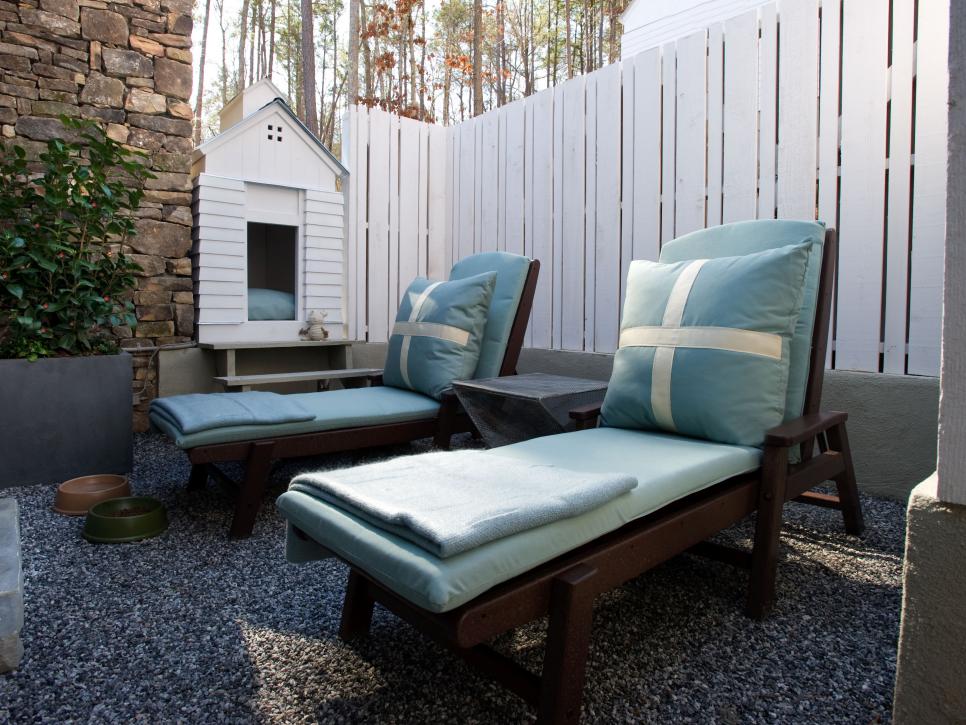 Courtyard With Blue Chaise Chairs, White Fence and White Dog House