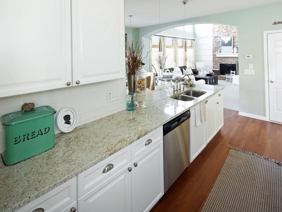 Light Green Kitchen With White Cabinets and Granite Countertop