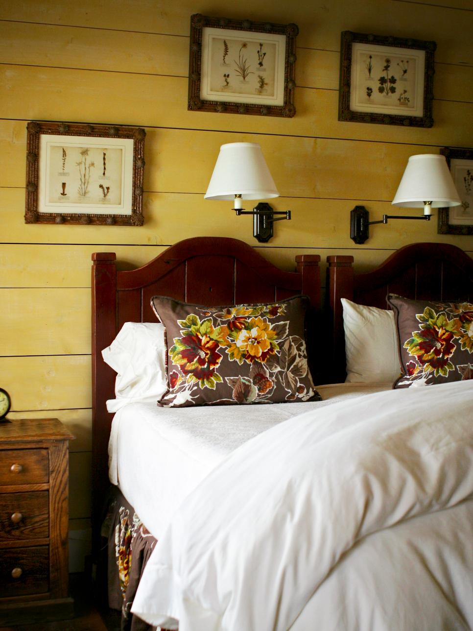 Yellow Bedroom With Wood Headboard, Floral Pillows and Botanical Prints