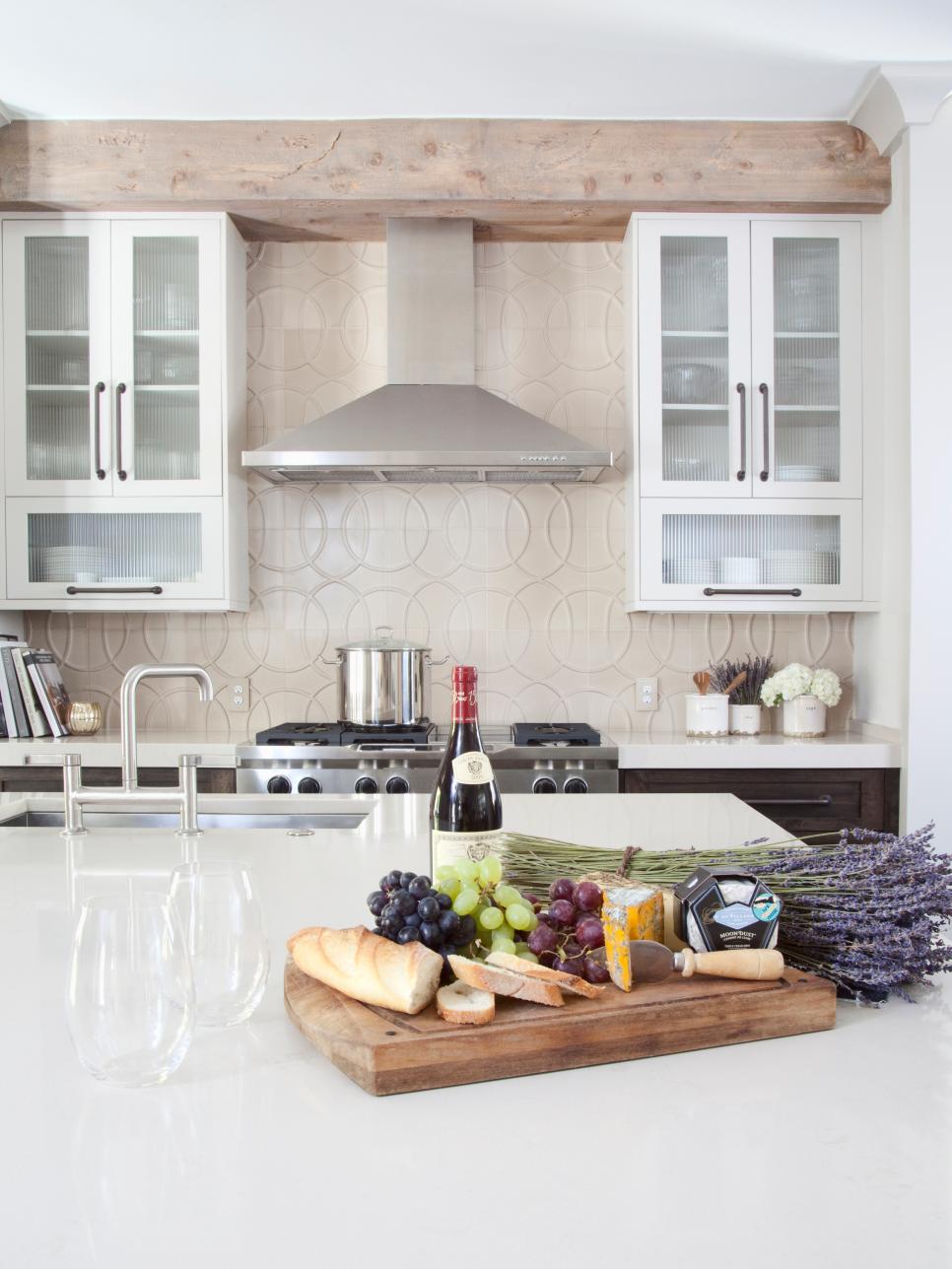 Kitchen With Stainless Hood, Tile Backsplash & White Island Countertop