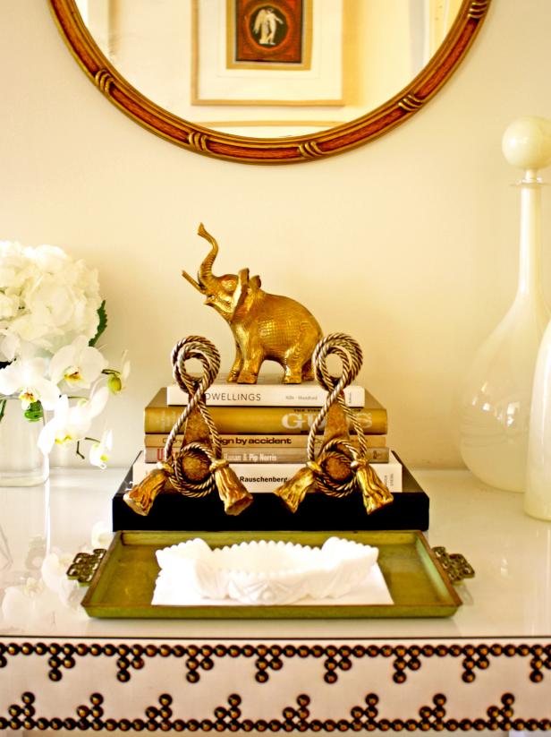 White Tabletop Vignette With Stacked Books and Gold Elephant White Tabletop Vignette With Stacked Books and Gold Elephant