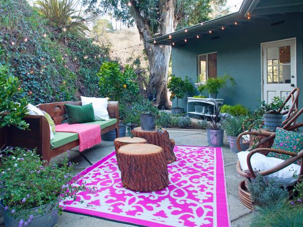 Bohemian Patio With Pink Outdoor Rug Graphic Pink Rug on Outdoor Patio With Tree Stumps, Wooden Bench