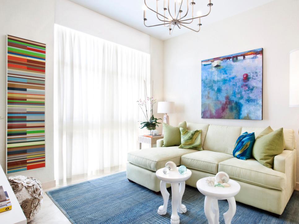 White Living Room With an Extended Sofa and Colorful Artwork