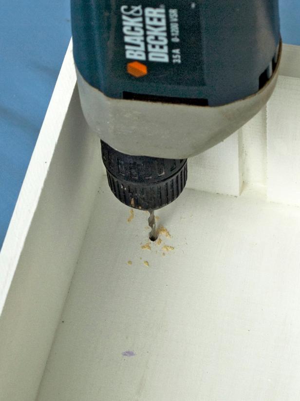 Using the chalk and ruler, measure and mark the locations for the knobs, spacing 4 knobs evenly across the top of each crate’s inside back wall. Pre-drill the holes for each knob (Image 1).