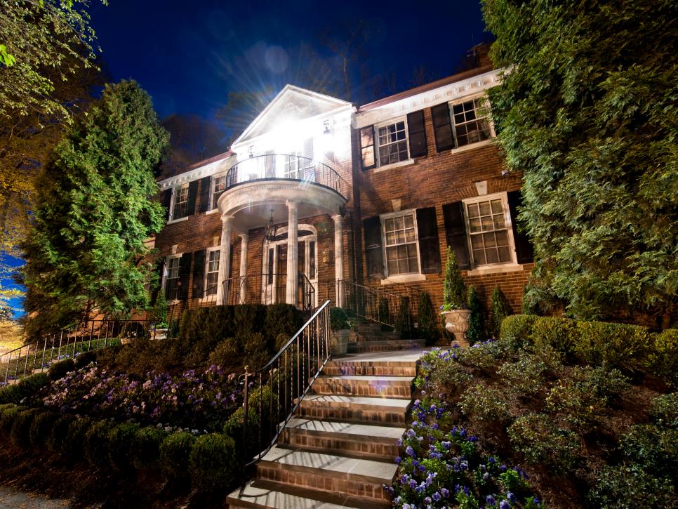 Colonial Brick Home Exterior With Columns & Landscaping at Night