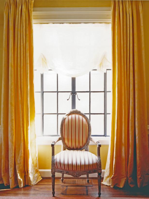 Gold Flowing Drapes in Front of a Large Pane of Old -Style Windows Gold Flowing Drapes in Front of a Large Pane of Old -Style Windows