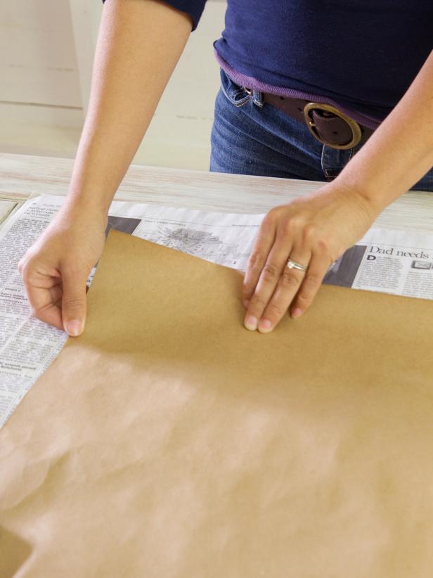 Put down a layer of newspaper topped with a sheet of craft paper to protect the work surface. Then select pumpkins of various sizes and colors, and decide which ones will receive which color glitter.