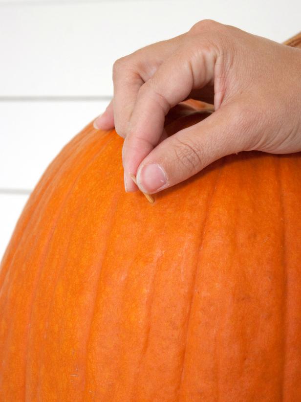 Push two toothpicks into the front of the large pumpkin where the eyes will be positioned. Gently push the bottom halves of the small pumpkins onto the toothpicks.