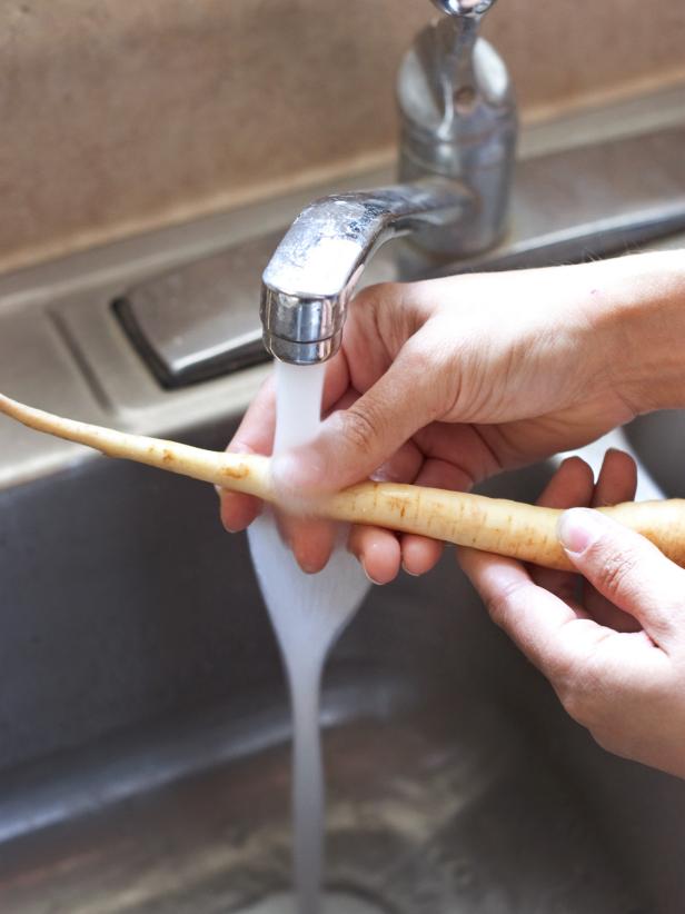 Woman washing root vegetables