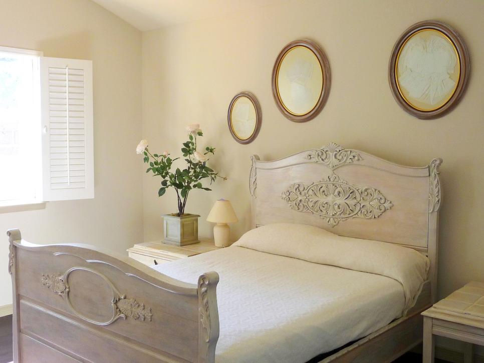 Neutral Cottage Bedroom With Potted Roses and Carved Bed Frame