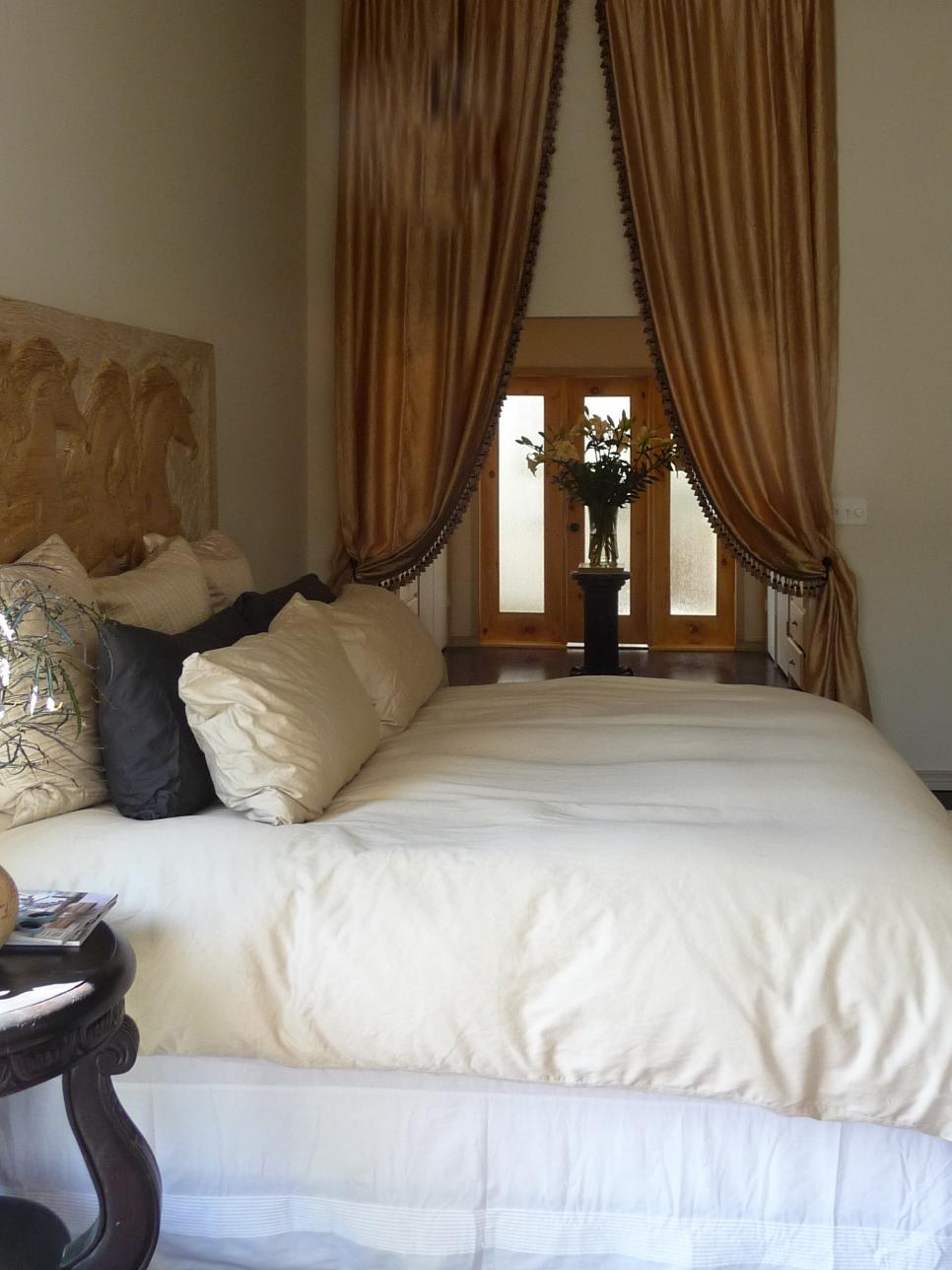 Transitional Bedroom With Plush White Bed and Gold Drapes