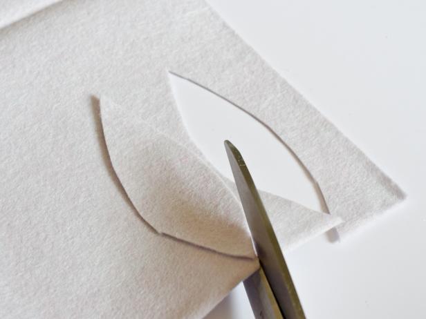 Using sharp scissors, cut darkest piece of felt in a strip that is 1 inch wide and long enough to wrap around the base of each tree form. For each topiary, cut 15-20 feather or leaf shapes out of all colors of felt — except the lightest shade — that measure 2-3 inches long and 1 inch wide. From the lightest shade, cut 6 feather or leaf shapes that measure 1-2 inches long and 1 inch wide. The shapes don't have to be exactly uniform; the first piece cut can serve as a template for the rest. Tip: A sharp pair of sewing scissors will cut through three layers of felt at a time to make this process go faster.