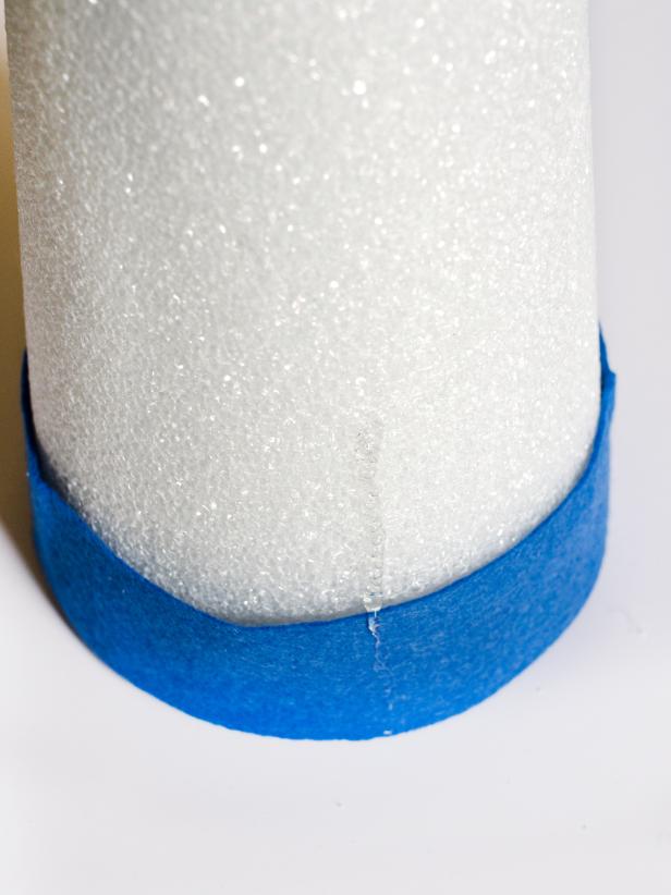 Apply hot glue in small sections around the base of each tree form and immediately press strip of darkest felt in place. Just above felt strip, apply a bead of hot glue vertically and immediately press the darkest felt feather into glue. Hold in place for few seconds until glue cools. Repeat with other dark felt feathers, placing them side by side so they slightly overlap, concealing the cone. Once the entire bottom row is finished, start a second row of dark felt feathers just above first row. Continue to glue feathers on, graduating from dark to light in rows of two. Tip: Use a moderate amount of hot glue. You don't want glue to squeeze out when felt feathers are pressed down.
