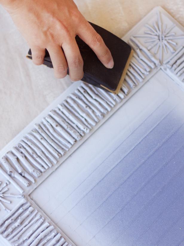 To create a birch bark effect, use a sanding block wrapped in sand paper to lightly sand the raised parts of each twig. Carefully remove painter's tape and clean mirror surface with window cleaner before hanging. Tip: Stubborn tape or paint can be removed with a razor blade.