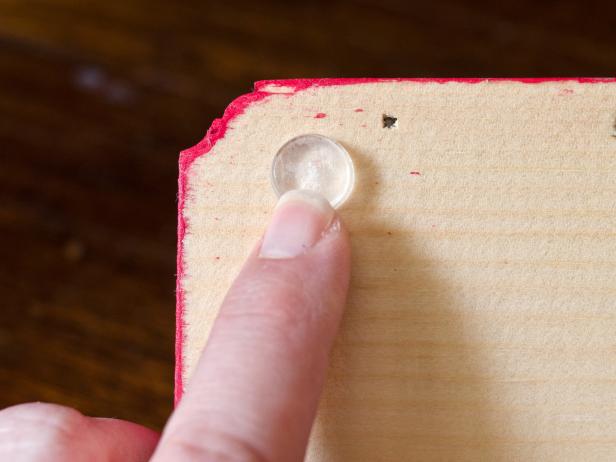 Stick clear adhesive-backed spacers onto back four corners of shelf. This will provide a "bumper" between the shelf and wall.