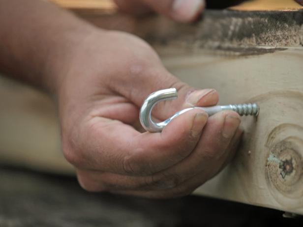 Drill two holes into the top of each frame for attaching C-hooks, spaced approximately 6 inches in from the outside edge. Next, screw C-hooks into holes in top of frame.