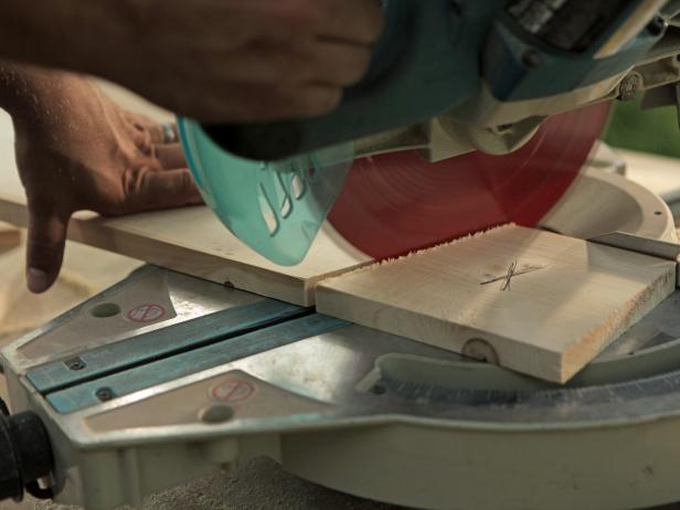 Using a circular saw, cut a pilot piece of the 1x6 pressure-treated pine that runs from the outside edge of the frame to the center of the middle 2X4; this should come to exactly 30 inches. Next, cut one edge off at a 22-1/2 degree angle using miter saw. After placing the cut piece onto the frame to ensure it is cut correctly, mark then cut the opposite end with miter saw at a 22-1/2 degree angle. Repeat the same marking and cutting process for all boards on the front and back sides of the partition.
