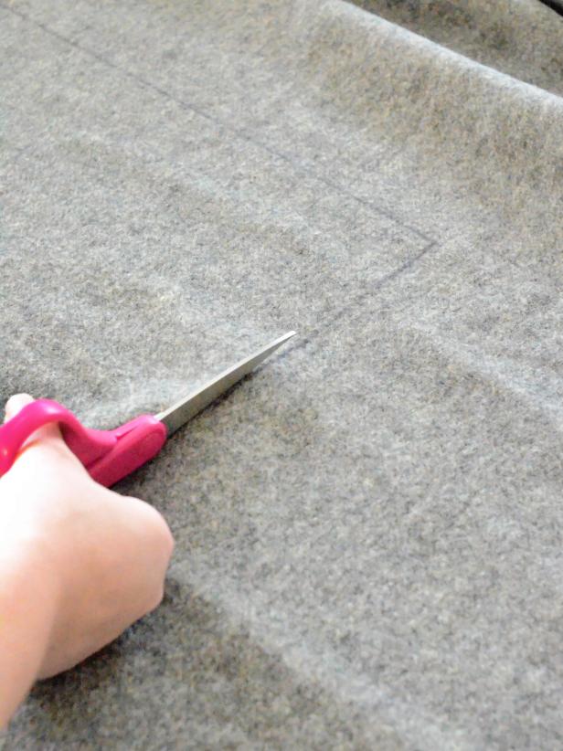 Carefully measure the square pattern for your Halloween cobweb pillow before cutting. Using a ruler and a marker, measure and mark two 18-1/2" x 18-1/2" squares of wool fabric. Cut out both squares with sharp scissors.