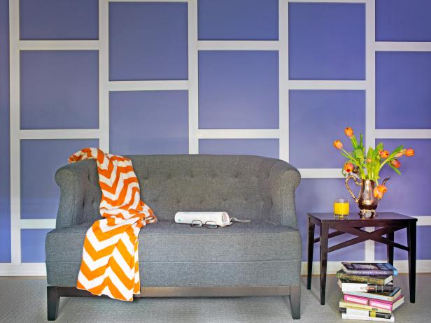 A bold paint color and simple molding turn a bare wall into a stunning focal point, nicely accented by a slate sofa for contrast.