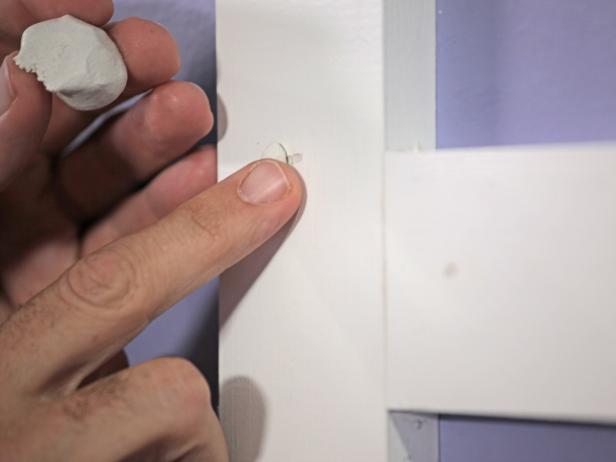 Once all vertical and horizontal pieces of MDF trim are installed, add spackle to holes, smooth out with spackle knife, caulk edges, then paint with paint brush.