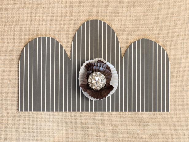 Use hot glue to attach a rhinestone bauble to the center of the liner flower.