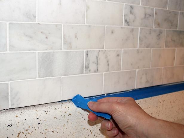 After grout has been cured and sealed, remove any remaining drop cloths or tape.
