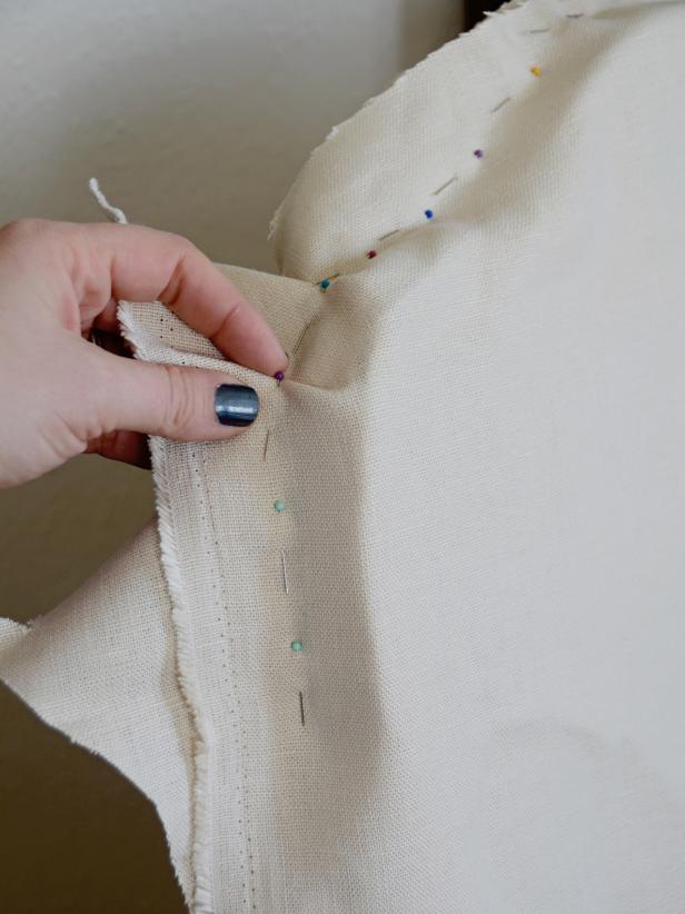 A slipcover is assembled or "pin fitted" inside out. If using a fabric with a clear right side, make sure right side is facing in toward the chair. Starting from the top of the chair back, pin front and back pieces together. Pin along the back line of the chair. It's best to pin the entire top, then alternate pinning a few inches down each side to prevent gaping in the back.