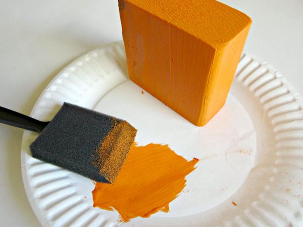 Start by painting the 2x4 blocks. When they've dried, sand the edges to create a shabby chic look.