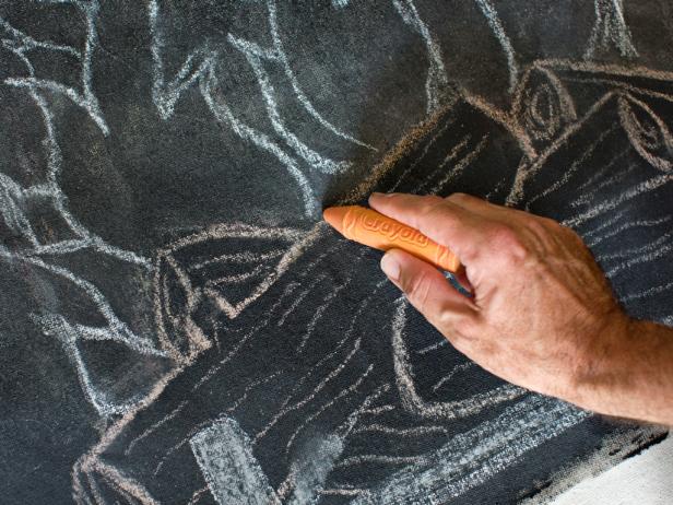 Once the chalk mantel drawing is complete, add burning logs to the mantel's opening with chalk to add a festive fireplace.