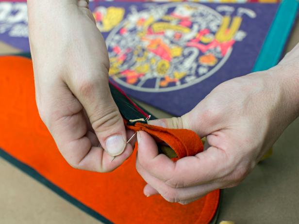 Thread needle then stitch the first two pennants together, starting from the top thick end of each pair of overlapping pennants.