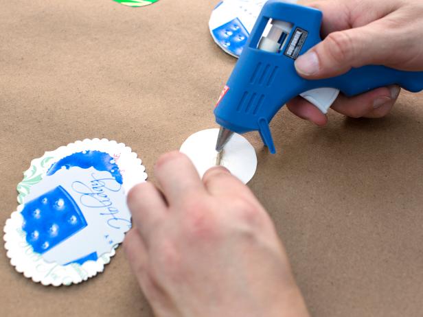 Unroll a section of twine along a flat, level surface. Use hot glue to attach twine to the back of a circle cut-out.