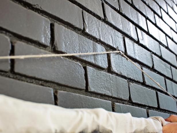 Hammer a picture-hanging nail into wall. Hang the drop cloth mantel by placing the knotted twine on the nail, moving the drapery rod back and forth until it sits perfectly level.