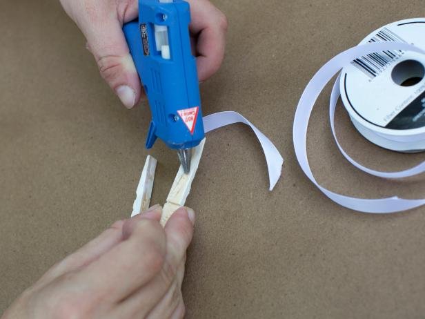 Add a bead of hot glue along the unpainted back of each of the two remaining clothespin pieces.