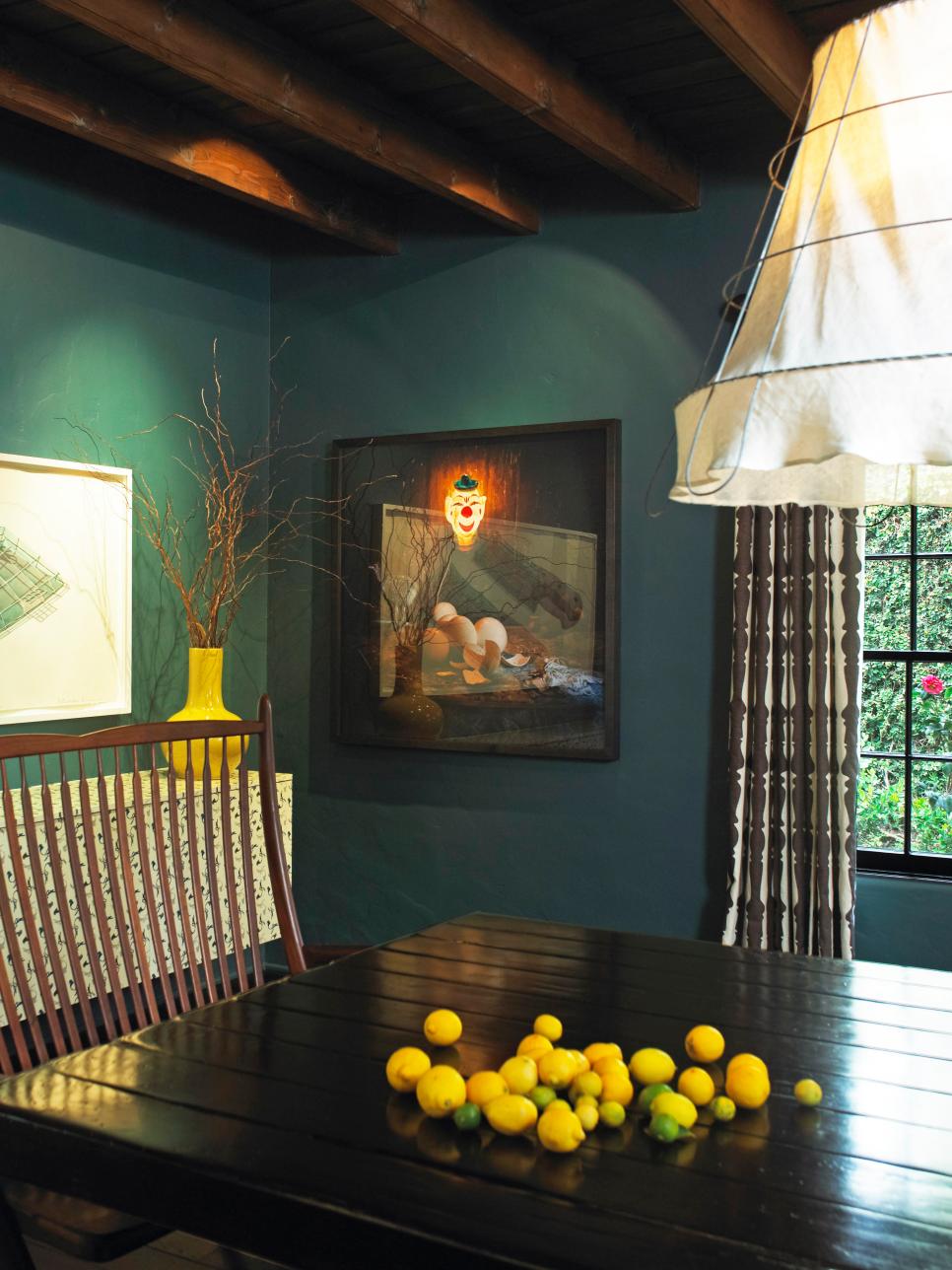 Dark Teal Blue Dining Room With Wood Beam Ceiling and Clown Art