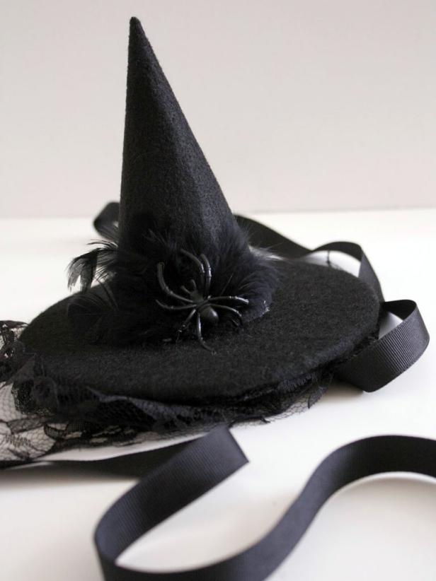 Add black feathers and spider, gluing in place. Attach a strip of lace along the underside of the circle, which looks like a veil. Finally, attach a 1 1/2' ribbon to the bottom of your circle and glue the second piece of black felt on top.