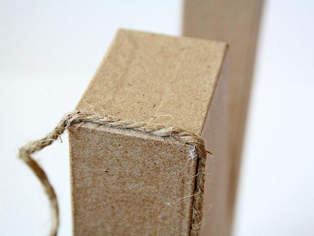 Start to vertically wrap the jute around the top section of the N. Put a dab of glue every so many inches to secure the jute to the letter.