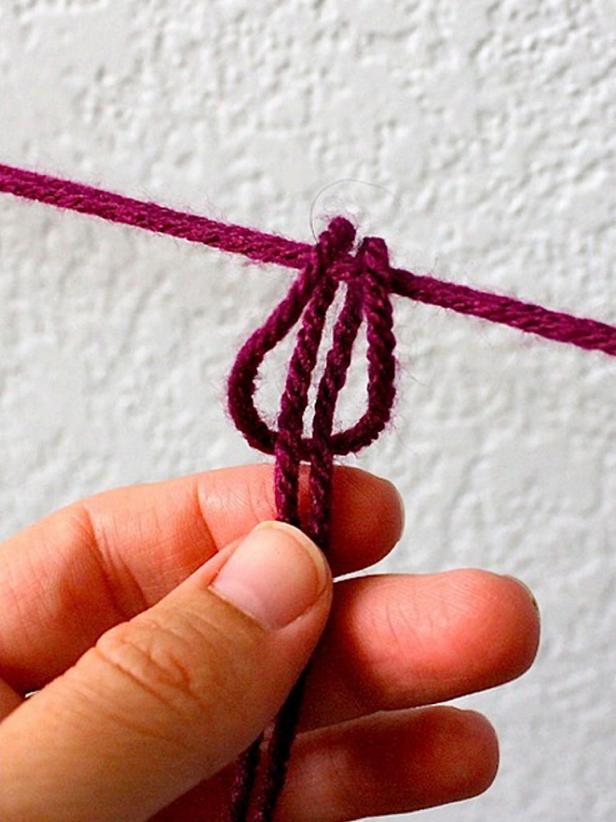 Cut a very long strand of yarn for each section — longer than you think you'll need. Fold it in half and start the ring with a simple loop knot. Then take the yarn around to each arm and simply loop it around. You don't need to tie knots — this is fast and easy. Don't try to be accurate and precise. It's better to look wonky here and there. When you get back around to beginning of the ring, tie the end with a knot, cut off the excess and start over on the next ring.