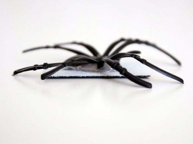 If the spider legs can get in the way of the magnet; you may need to tilt it upward and use a lot of hot glue so the magnet will fully stick to the metal surface. You don't want the magnet to bend or ripple at all.