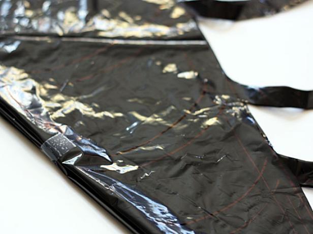 This is slippery stuff, so use a few pieces of tape to fasten the layers together on the loose side. It will help hold the shape together when you're cutting. If any of your tape pieces end up on the web itself after you've cut it out, remove them before unfolding.