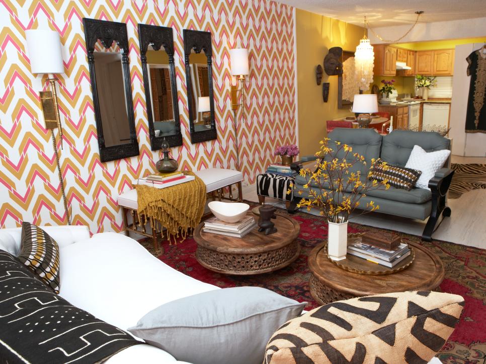 Eclectic Living Room With Gold Patterned Wallpaper and Black Mirrors