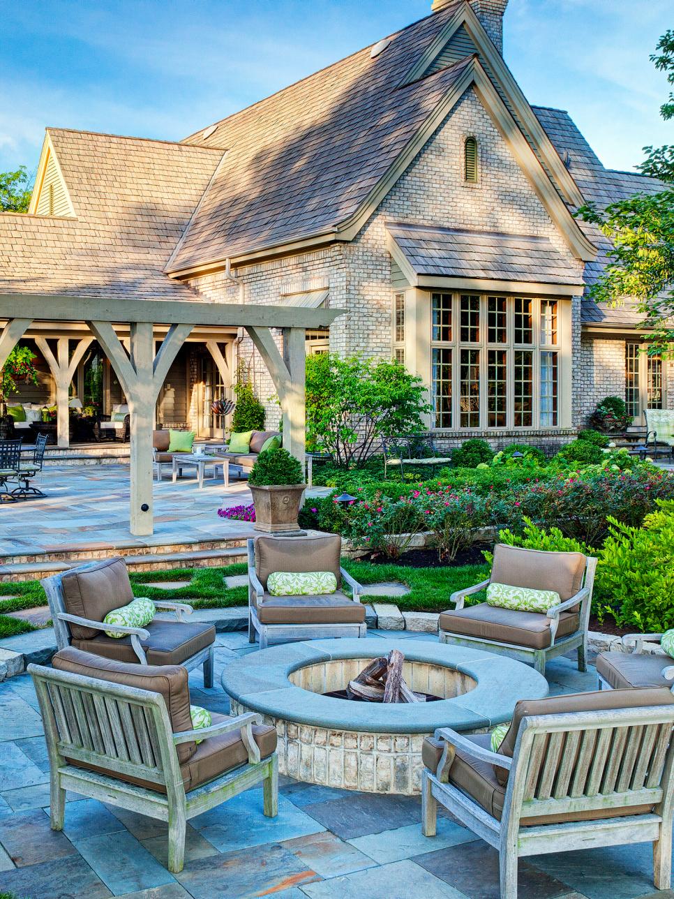 Exterior of Traditional Brick Home With Round Fire Pit, Wood Chairs