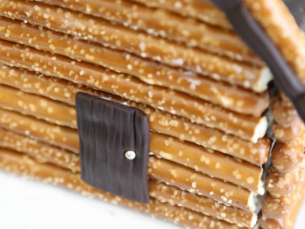 Adhere the chocolate fondant door to the pretzel facade using a dab of royal icing.