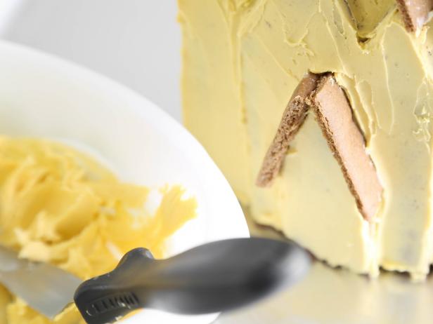 Cover the front, back, sides and roof of the house with <a href="http://www.hgtv.com/entertaining/easy-royal-icing-recipe/index.html">royal icing</a> in a soft yellow hue.