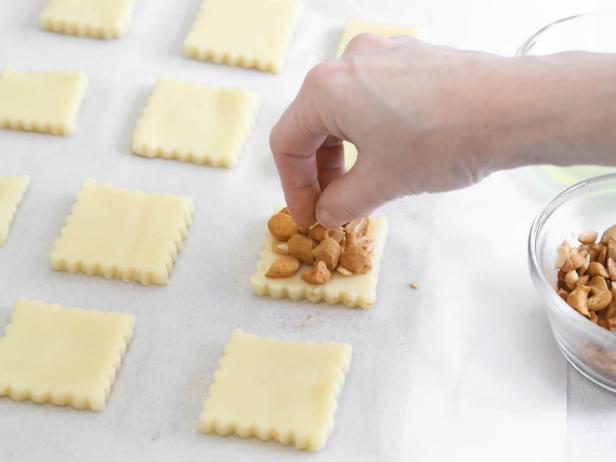 Chop salted cashews and divide evenly over cut squares .
