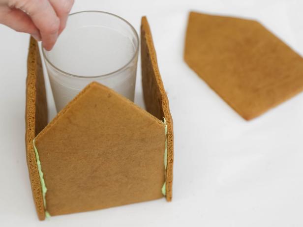 Attach a side piece on either side, butting the short ends against the candy-coated short ends of the front piece. Hold the pieces in place for 2-3 minutes, or use a tall tumbler as a prop.