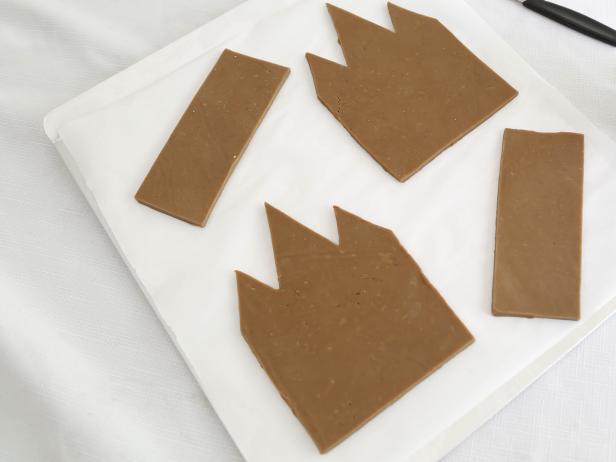 In step 4 of this project, use the Victorian house template to cut pieces from the gingerbread dough, and transfer to prepared sheets, spacing two inches apart. Bake one sheet at a time until cookies are firm on top and slightly darker around edges, about 8 minutes for smaller shapes and up to 15 minutes for larger shapes.