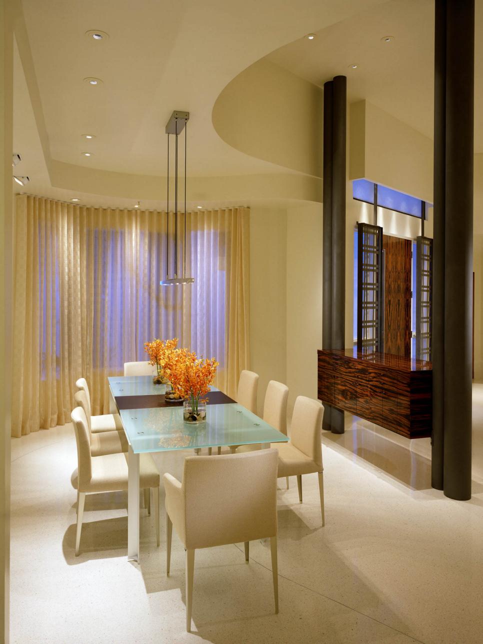 Modern Neutral Dining Room With Glass Dining Table and Wood Buffet
