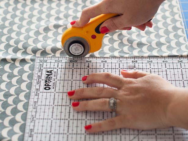 Line up the quilting ruler with the pattern then use a rotary cutter to cut it out. Also, cut one piece of felt using the felt flap pattern and one piece of lining fabric using the lining flap pattern.
