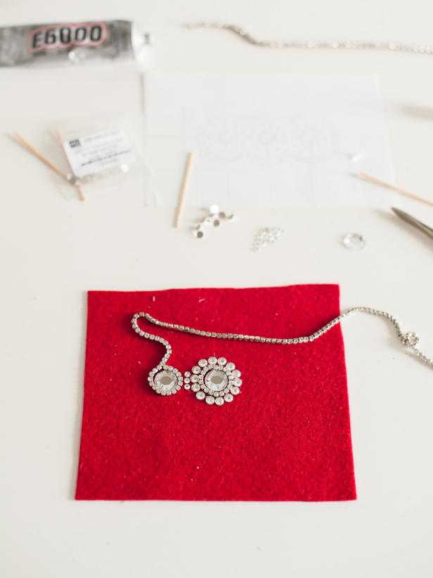 Continue attaching crystals and rhinestone trim to complete the design on the custom headpiece.