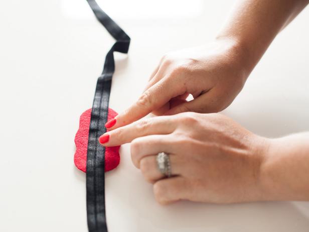 Apply a line of glue to the back of the rhinestone piece then place the center of the elastic band on top of the glue. Press in place and allow to dry.